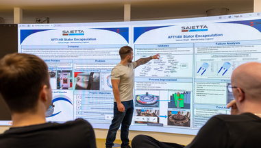 Student giving a poster presentration on a big screen