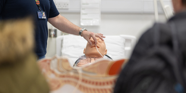 An academic carrying out a cardiology demonstration on a manikin