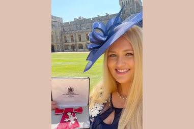 Woman holding an MBE medal