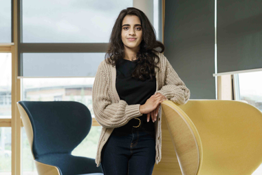 Woman standing beside a chair