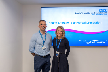 Two people standing infront of a screen