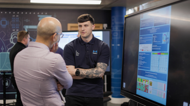 Two men standing infront of a screen