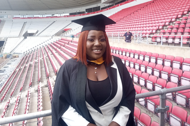 Student in cap and gown at the Stadium of Light