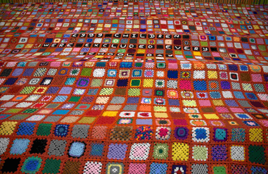 Front view of the giant patchwork blanket with hundreds of hand-stitched colourful squares
