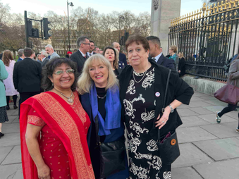 Academic stood with radio managers outside of Buckingham Palace