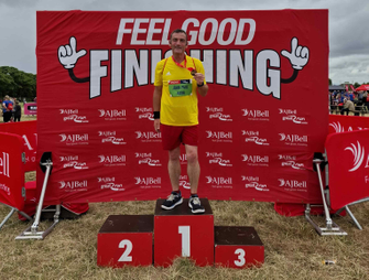 Man standing holding a medal