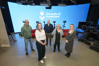 Group of people standing in TV studio