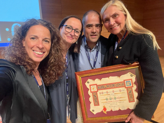 Four people standing holding an award