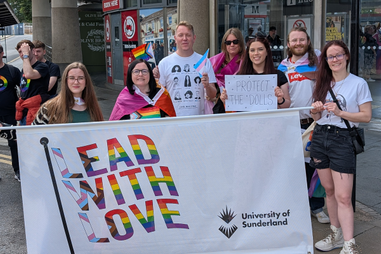 Staff wearing pride flags and holding banners