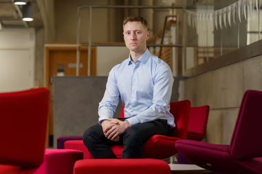 Professor Matthew Campell sitting on red chair