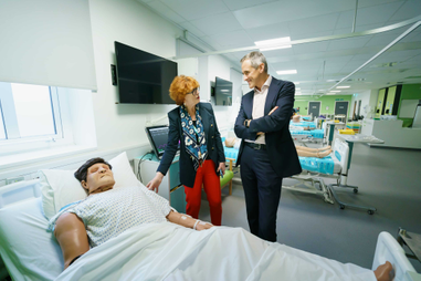 Two people standing in a mock hospital ward