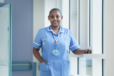 Female nurse standing by window