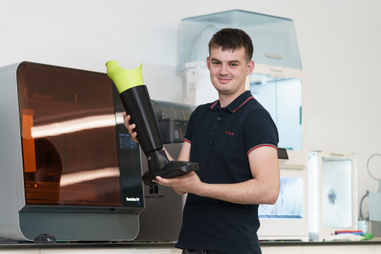 Graduate holding prosthetic leg