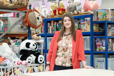 Apprentice stood in warehouse full of toys