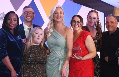 Group of people standing with an award