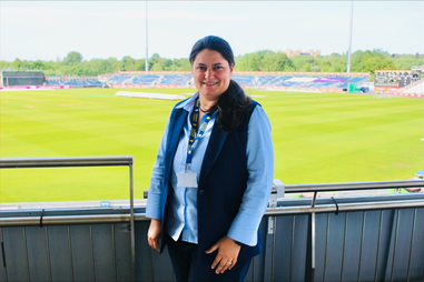 Woman standing infront of cricket pitch