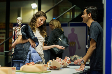 Attendee at event station looking at models