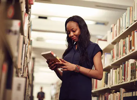 Student reading a book in the library