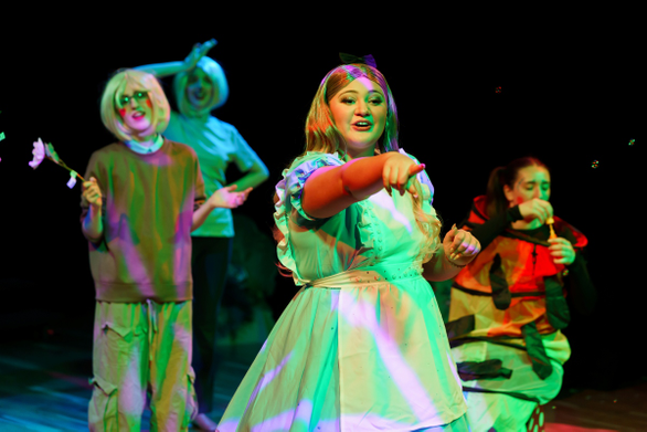 Student pointing in front of other actors