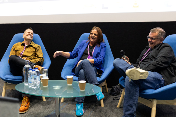 Speakers sat on chairs laughing