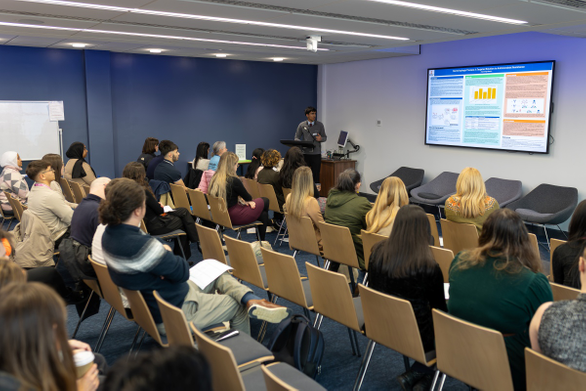 Room full of students and staff sat down watching a presentation