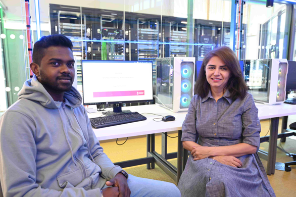 student and academic sat in front of a computer