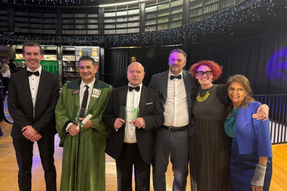 Academics stood together, two are holding awards