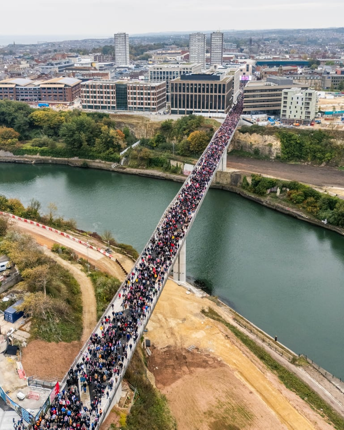 Thousands of people crossing a bridge