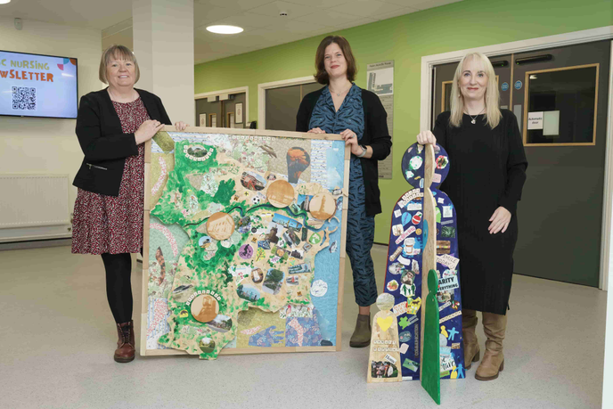 Three people standing with artwork