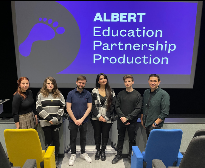 Students and academic stood together in cinema