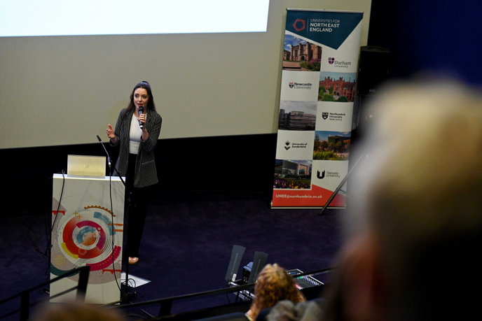 Speaker presenting at the front of lecture hall
