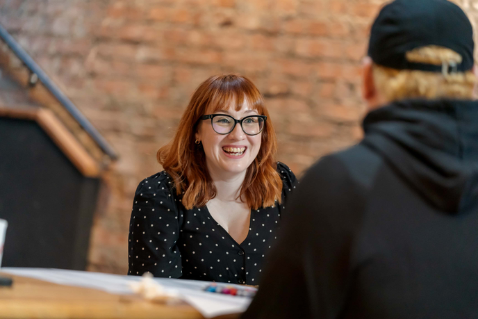 Dr Becky Allen sitting around a table with musicians at the AI in Music event at Pop Recs in Sunderland