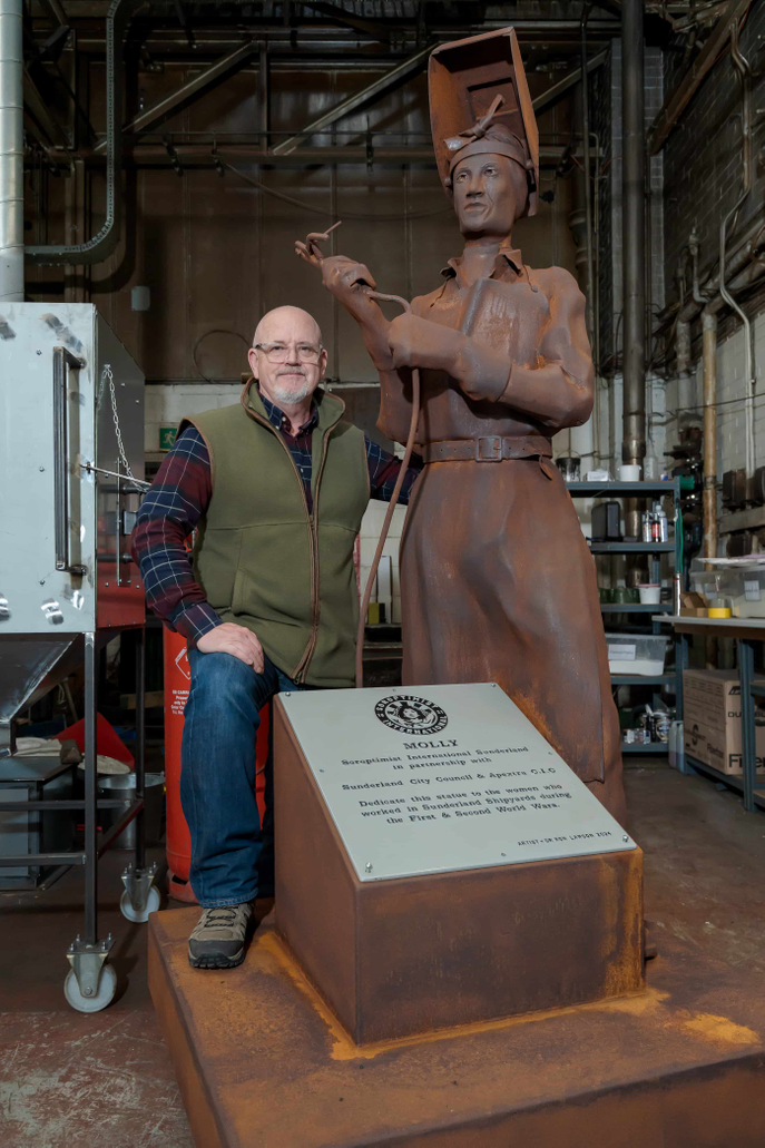 Dr Ron Lawson standing beside the Molly sculpture