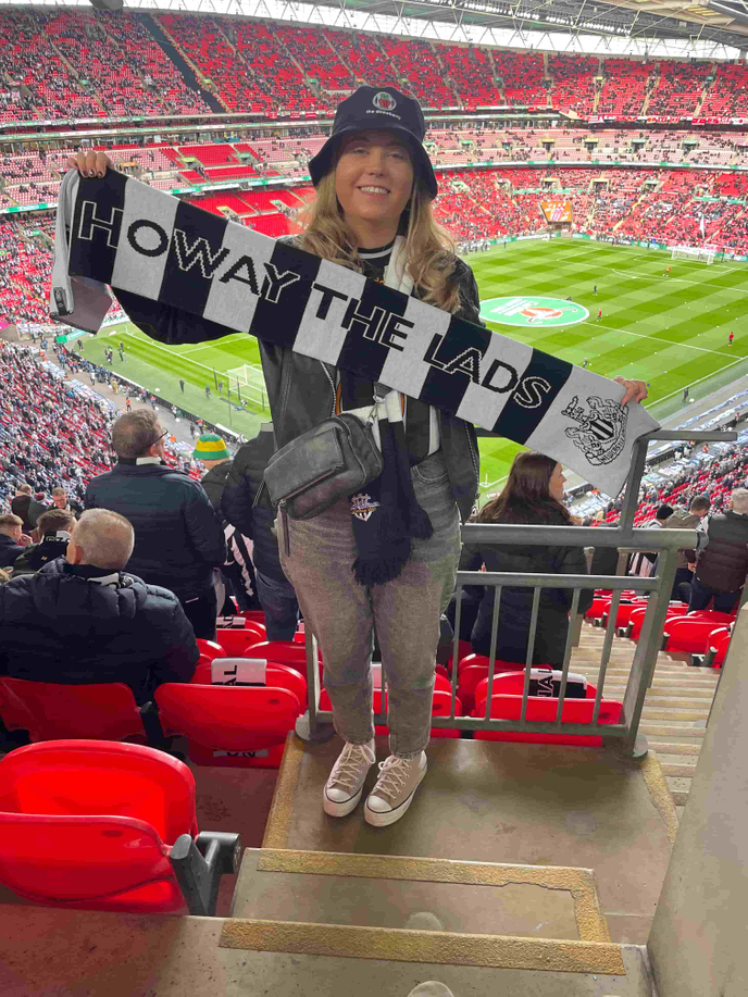 Chaplain stood in stadium with football scarf