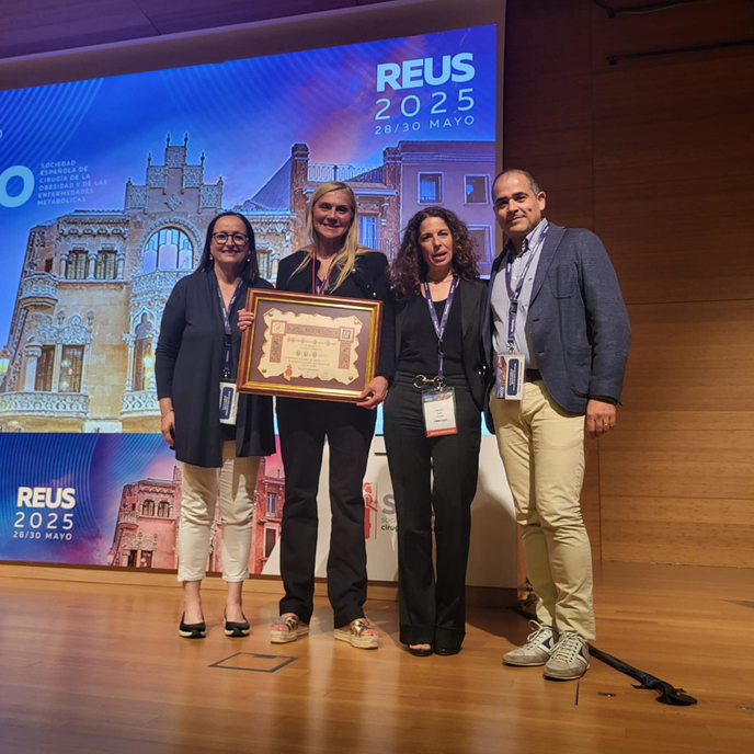 Four people standing holding an award