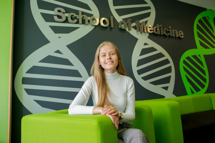 Laura Giles sitting inside the University of Sunderland's School of Medicine