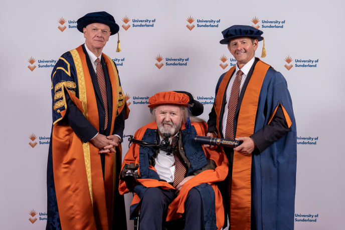 Three men at graduation ceremony