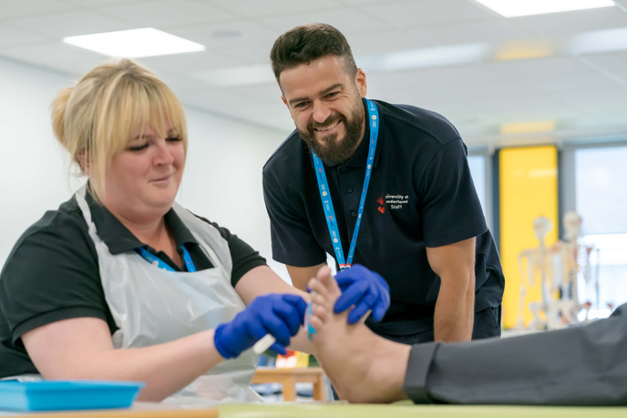 Lecturer advising a student using a scalpel