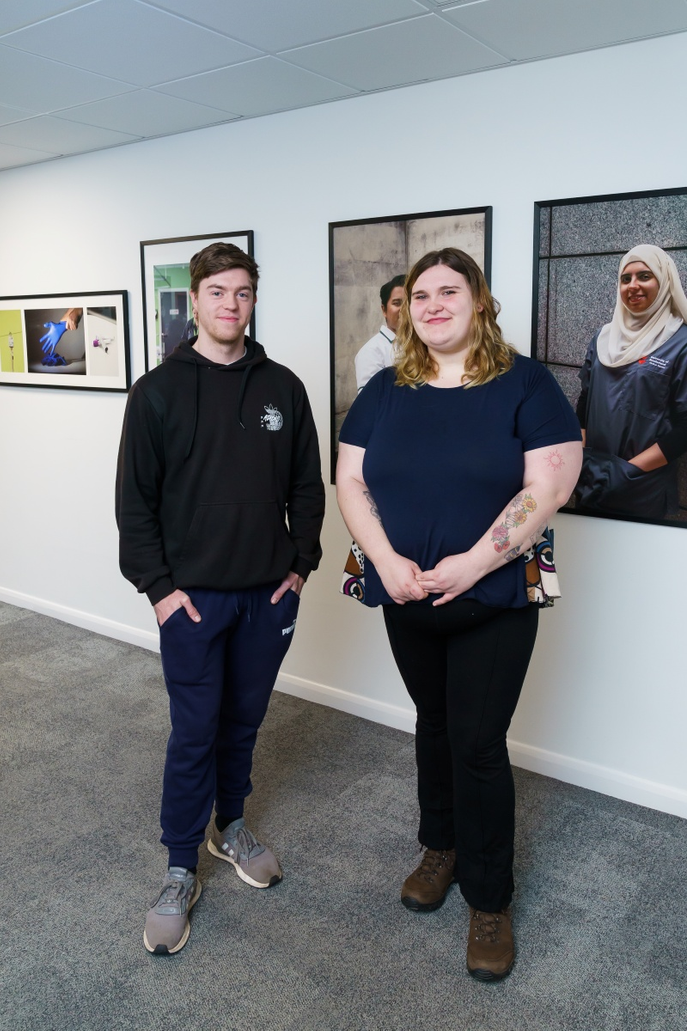 Students stood in front of photographs