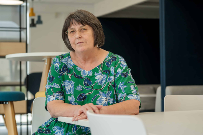 Dr Diane Simpson sitting with her arms resting on a table