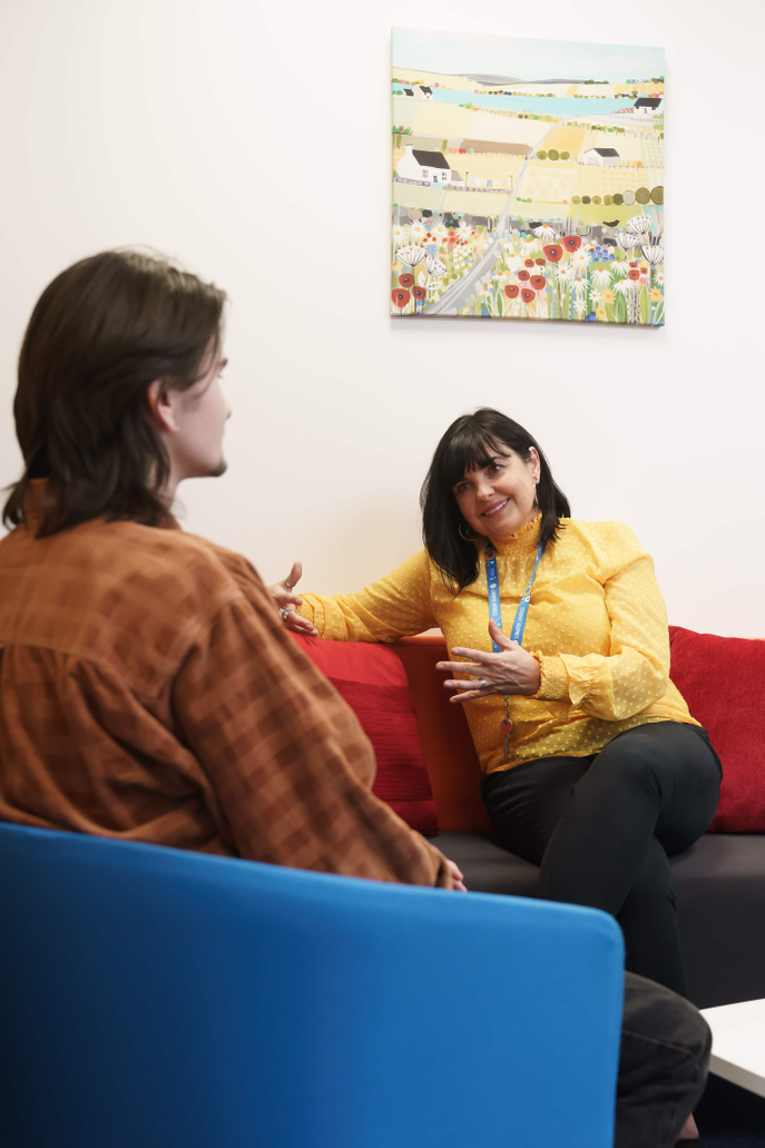 Staff and Student talking on sofa
