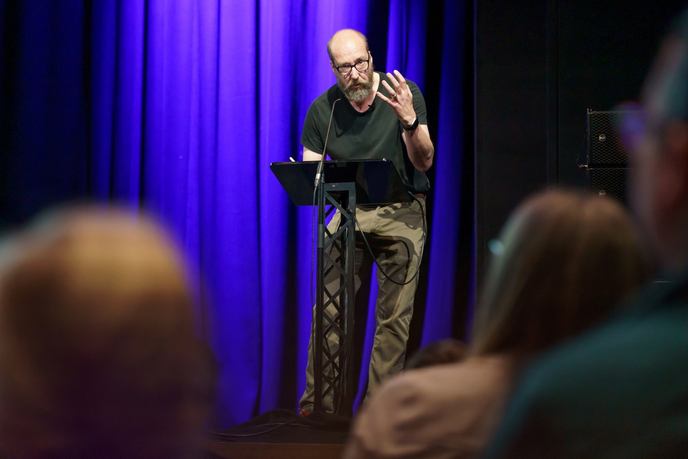 Academic delivering a talk at a podium
