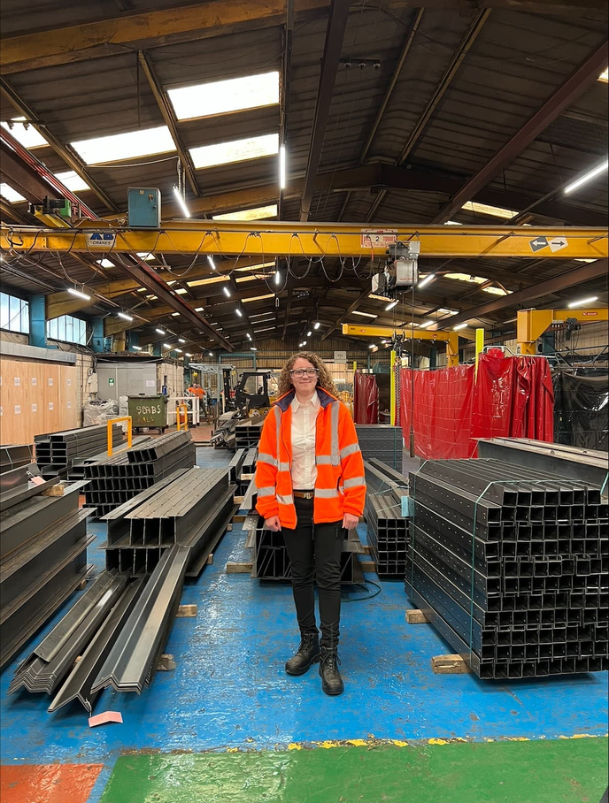 Olivia standing next to construction equipment at Birtley Group