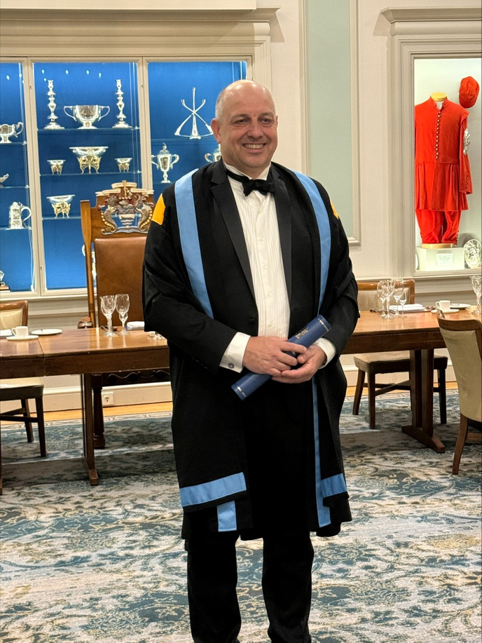 Graduate stood wearing ceremonial robes