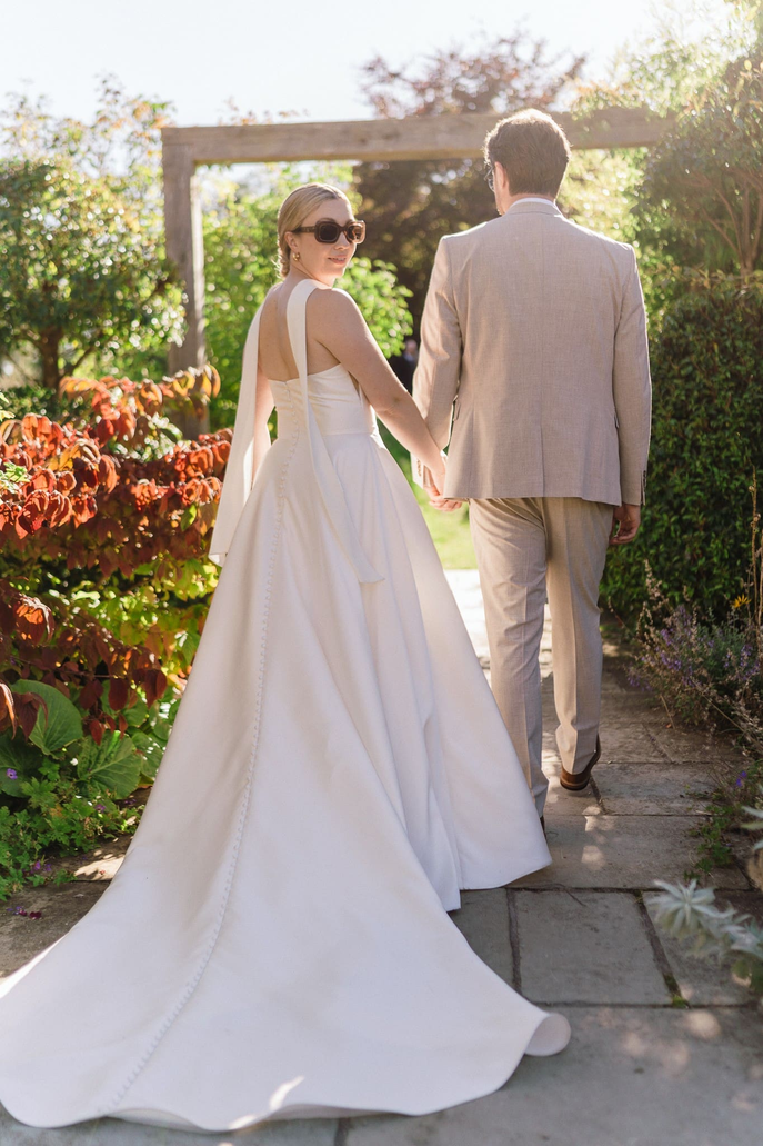 Graduates at their wedding walking in garden