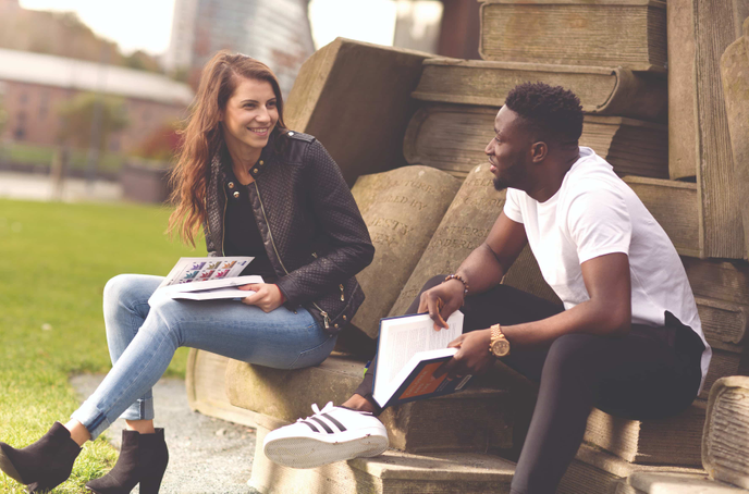 Students sitting talking outside the University of Sunderland