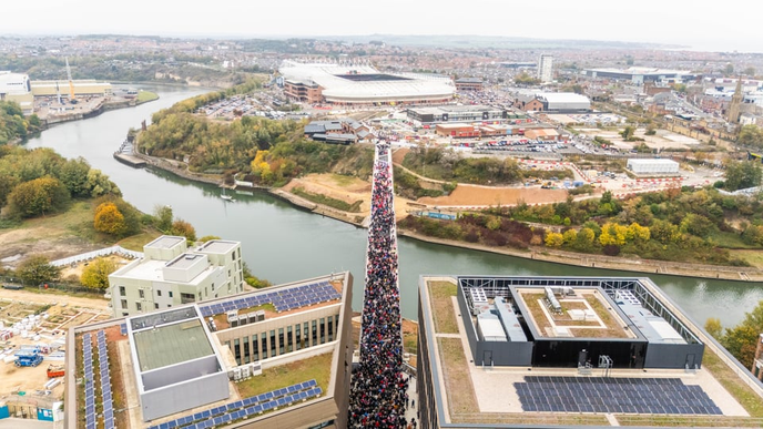 Thousands of people crossing a bridge