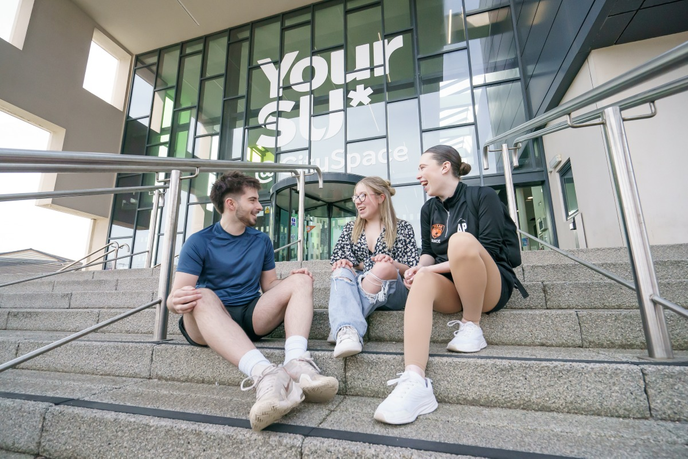 Students sat outside university building