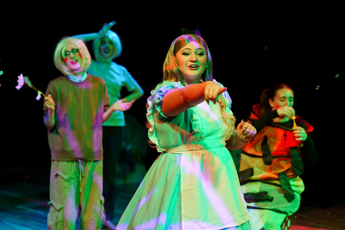 Student pointing in front of other actors