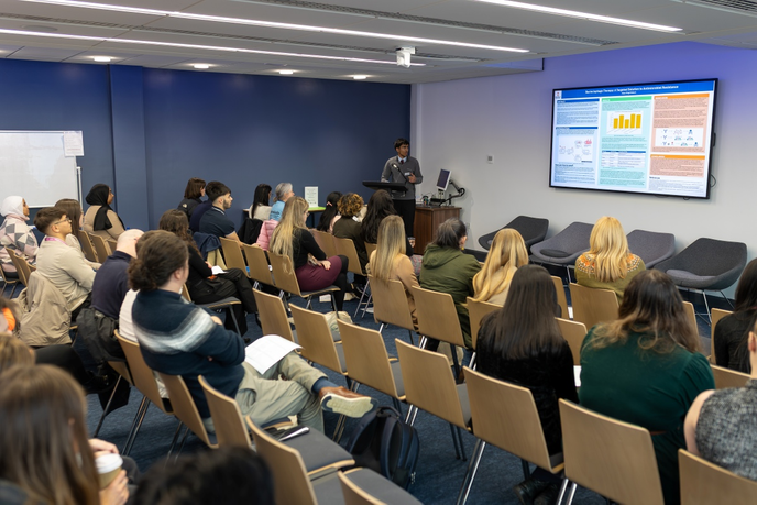 Room full of students and staff sat down watching a presentation